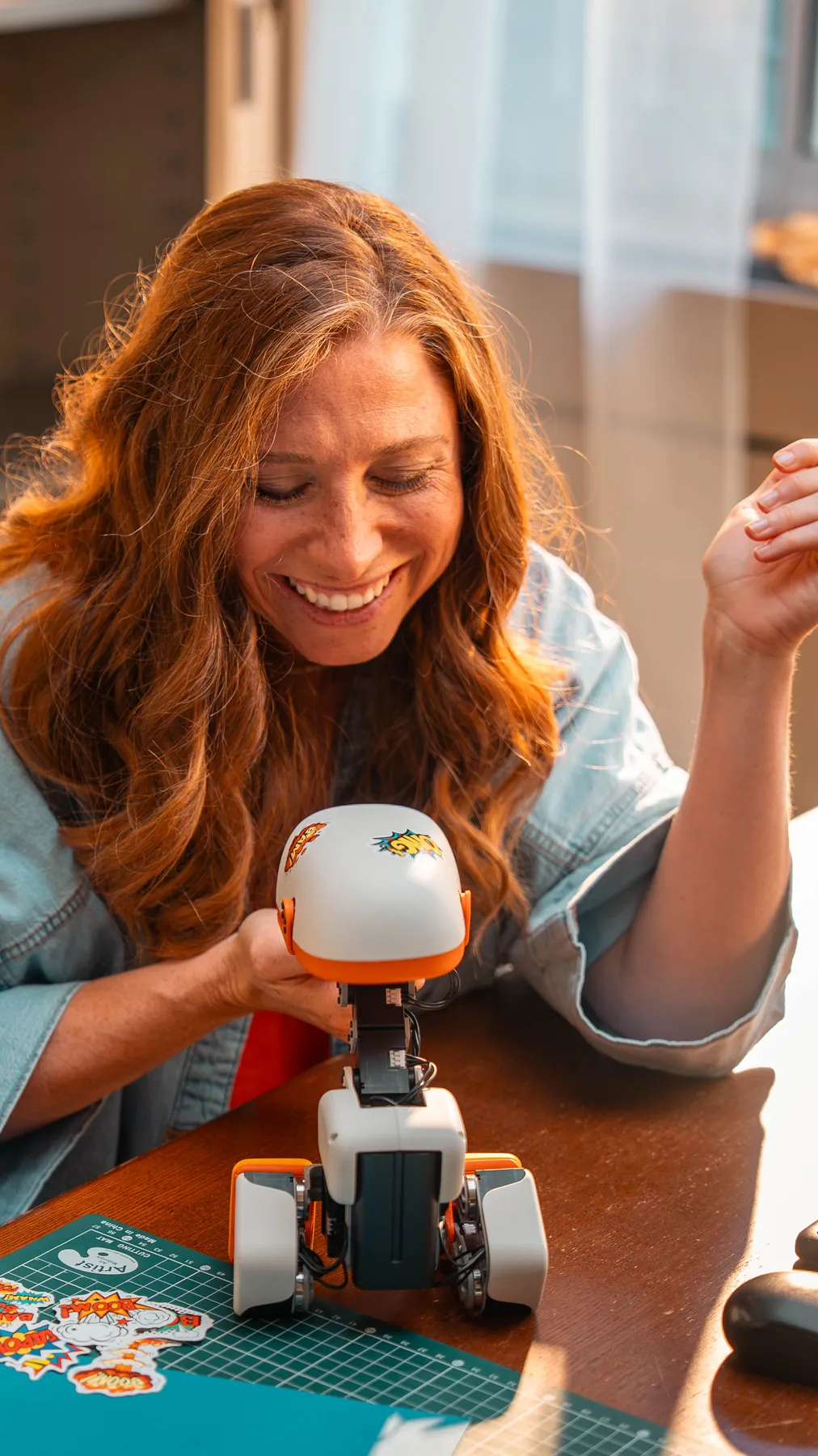 A woman laughing while playing with a MACRODUCK at a table