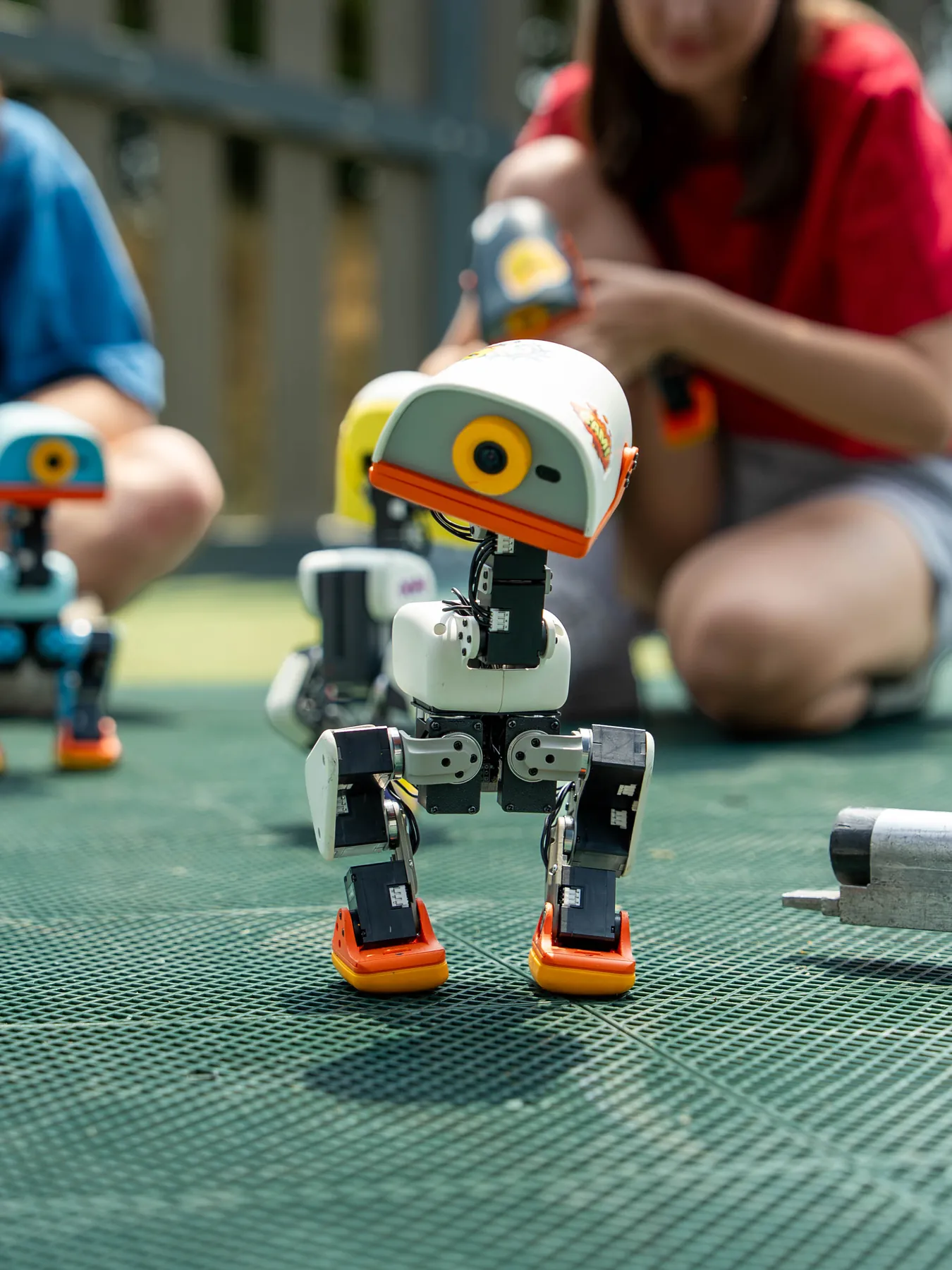 A MACRODUCK walking across a green games table surrounded by people
